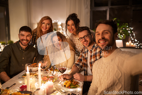 Image of friends taking selfie at christmas dinner party