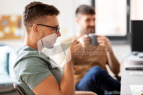 Image of men or startuppers drinking coffee at office