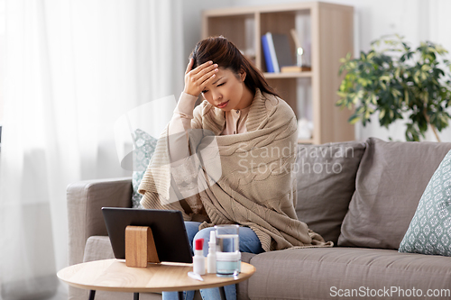 Image of sick woman having video call on tablet pc at home