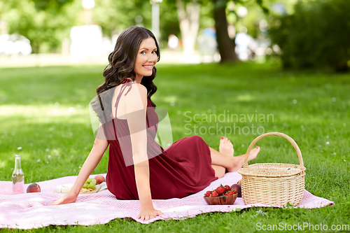 Image of happy woman with picnic basket at summer park