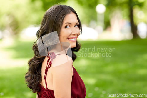 Image of portrait of happy smiling woman at summer park