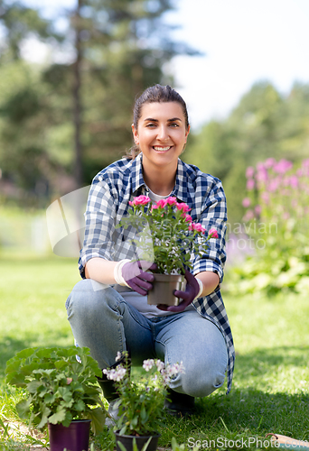 Image of woman planting rose flowers at summer garden