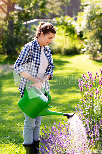 Image of young woman watering flowers at garden