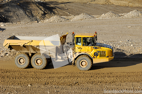 Image of Yellow dump truck working in gravel pit