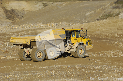 Image of Yellow dump truck working in gravel pit