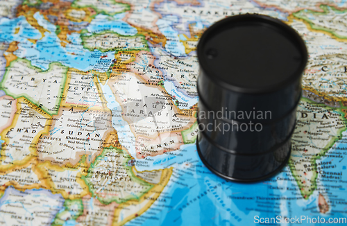Image of Oil drum with crude petroleum standing on a map