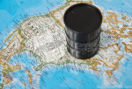 Image of Oil drum with crude petroleum standing on a map