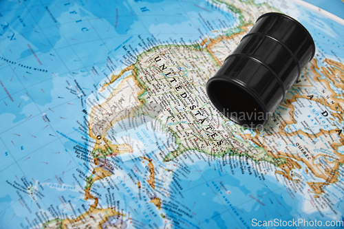 Image of Oil drum with crude petroleum lying on a map