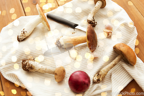 Image of edible mushrooms, kitchen knife and towel