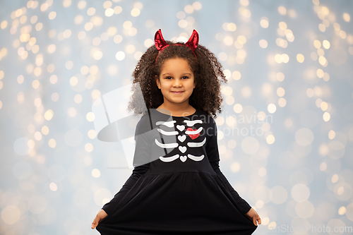 Image of girl in black dress and devil's horns on halloween