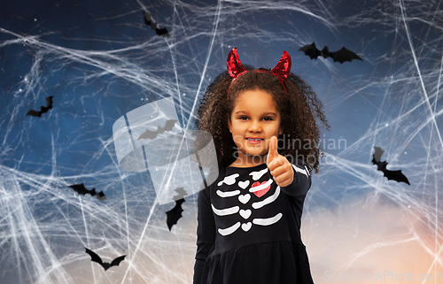 Image of girl in black dress and devil's horns on halloween