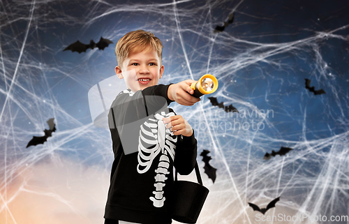 Image of boy with candies and flashlight on halloween