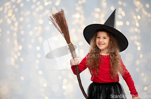 Image of girl in black witch hat with broom on halloween