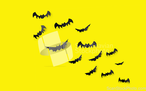Image of flock of black paper bats over yellow background