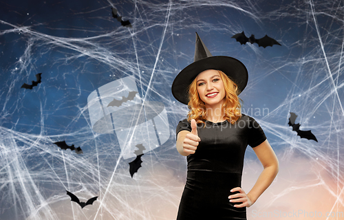 Image of happy woman in black halloween costume of witch