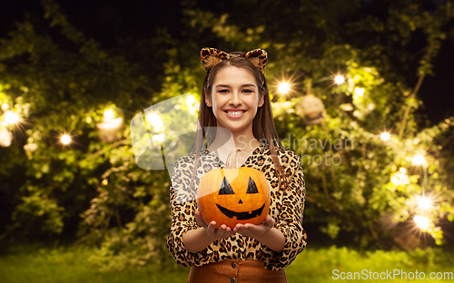 Image of woman in halloween costume of leopard with pumpkin