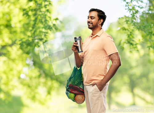 Image of man with food in bag and tumbler or thermo cup