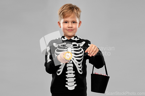 Image of boy with candies and flashlight on halloween