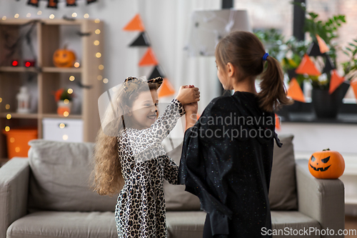 Image of girls in halloween costumes dancing at home