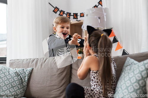 Image of kids in halloween costumes playing at home