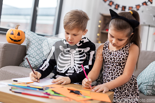 Image of kids in halloween costumes doing crafts at home