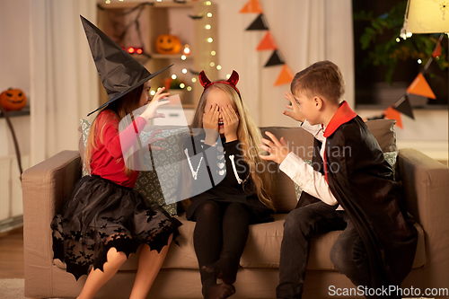 Image of kids in halloween costumes playing at home