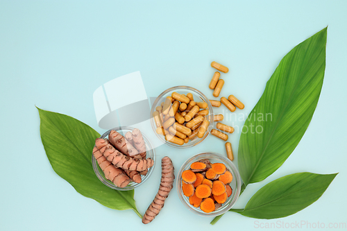 Image of Fresh Turmeric Root Herb with Supplement Capsules and Leaves