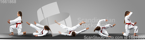 Image of Young judo caucasian female fighter in white kimono with red belt in motion and action during training. Practicing martial arts fighting skills.