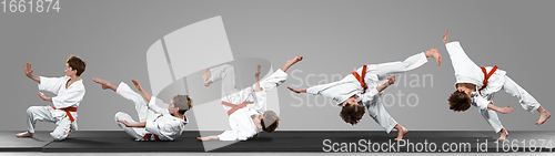 Image of Young judo caucasian male fighter in white kimono with red belt in motion and action during training. Practicing martial arts fighting skills.