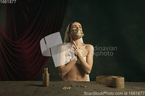 Image of Modern remake of classical artwork with coronavirus theme - young medieval woman on dark background