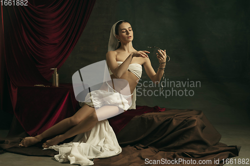 Image of Modern remake of classical artwork with coronavirus theme - young medieval woman on dark background