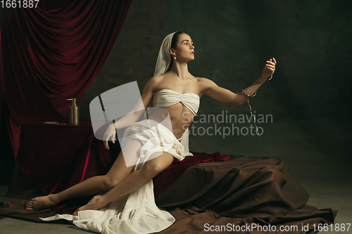 Image of Modern remake of classical artwork with coronavirus theme - young medieval woman on dark background