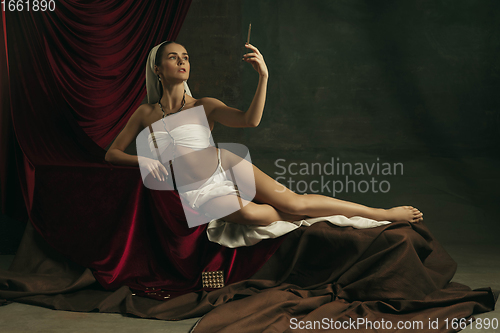 Image of Modern remake of classical artwork with coronavirus theme - young medieval woman on dark background