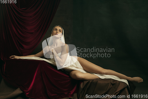 Image of Modern remake of classical artwork with coronavirus theme - young medieval woman on dark background