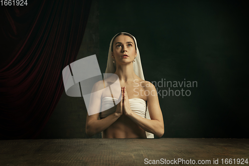 Image of Modern remake of classical artwork. Young medieval woman on dark background