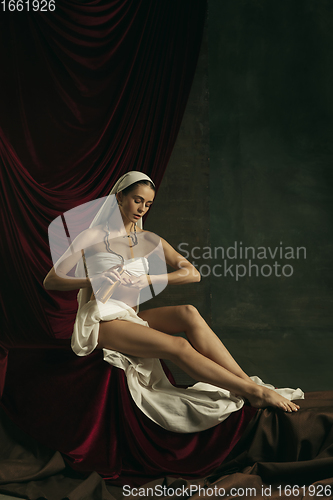 Image of Modern remake of classical artwork with coronavirus theme - young medieval woman on dark background