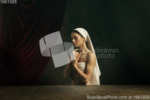 Image of Modern remake of classical artwork. Young medieval woman on dark background