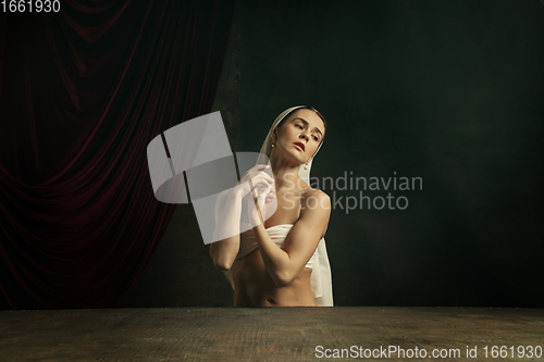 Image of Modern remake of classical artwork. Young medieval woman on dark background