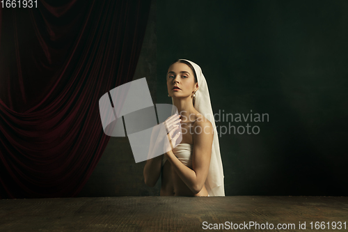 Image of Modern remake of classical artwork. Young medieval woman on dark background