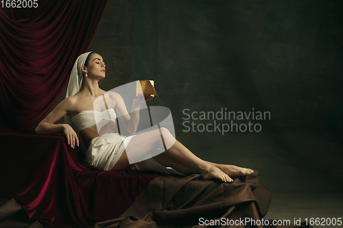 Image of Modern remake of classical artwork with coronavirus theme - young medieval woman on dark background