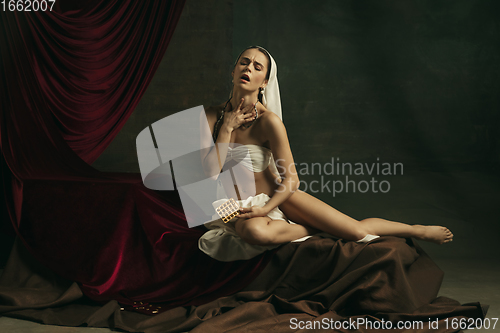 Image of Modern remake of classical artwork with coronavirus theme - young medieval woman on dark background