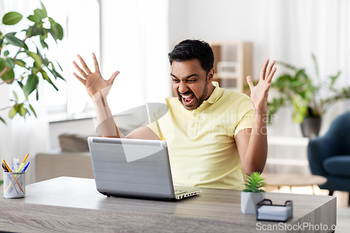 Image of angry man with laptop working at home office