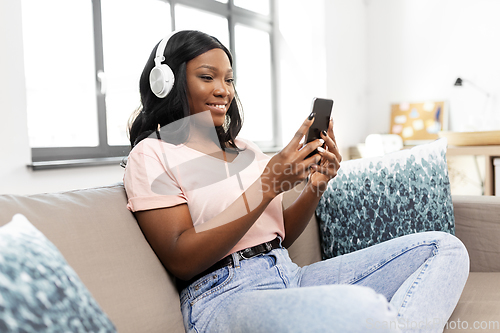 Image of woman with smartphone listening to music at home