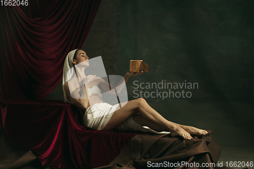 Image of Modern remake of classical artwork with coronavirus theme - young medieval woman on dark background