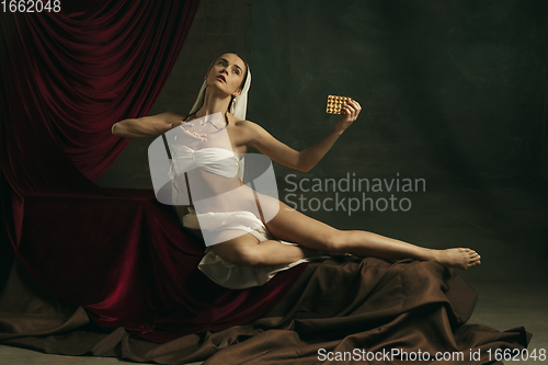 Image of Modern remake of classical artwork with coronavirus theme - young medieval woman on dark background