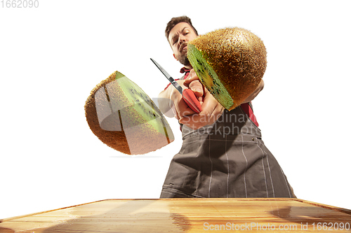Image of Amazing caucasian man preparing unbelievable food with action, details and bright emotions, professional cook isolated on white studio background.