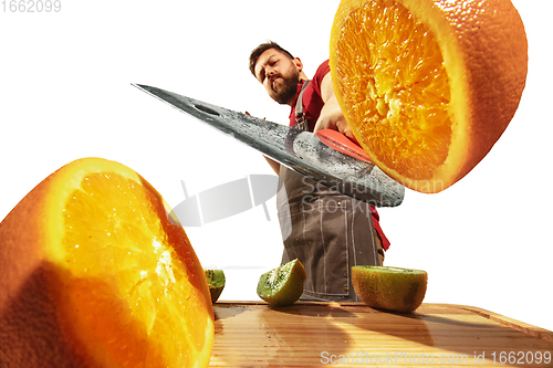 Image of Amazing caucasian man preparing unbelievable food with action, details and bright emotions, professional cook isolated on white studio background.