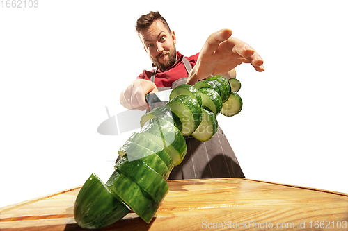 Image of Amazing caucasian man preparing unbelievable food with action, details and bright emotions, professional cook isolated on white studio background.