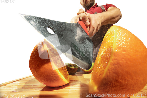 Image of Amazing caucasian man preparing unbelievable food with action, details and bright emotions, professional cook isolated on white studio background.