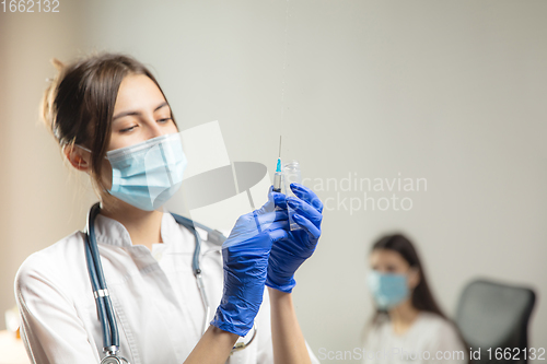 Image of Doctor or nurse giving vaccine to patient using the syringe injected in hospital